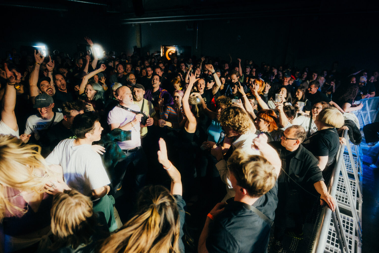 Bild von einem Festival Konzert aus der ersten Reihe. Menschen feiern ausgelassen einen Sänger und jubeln ihm zu.